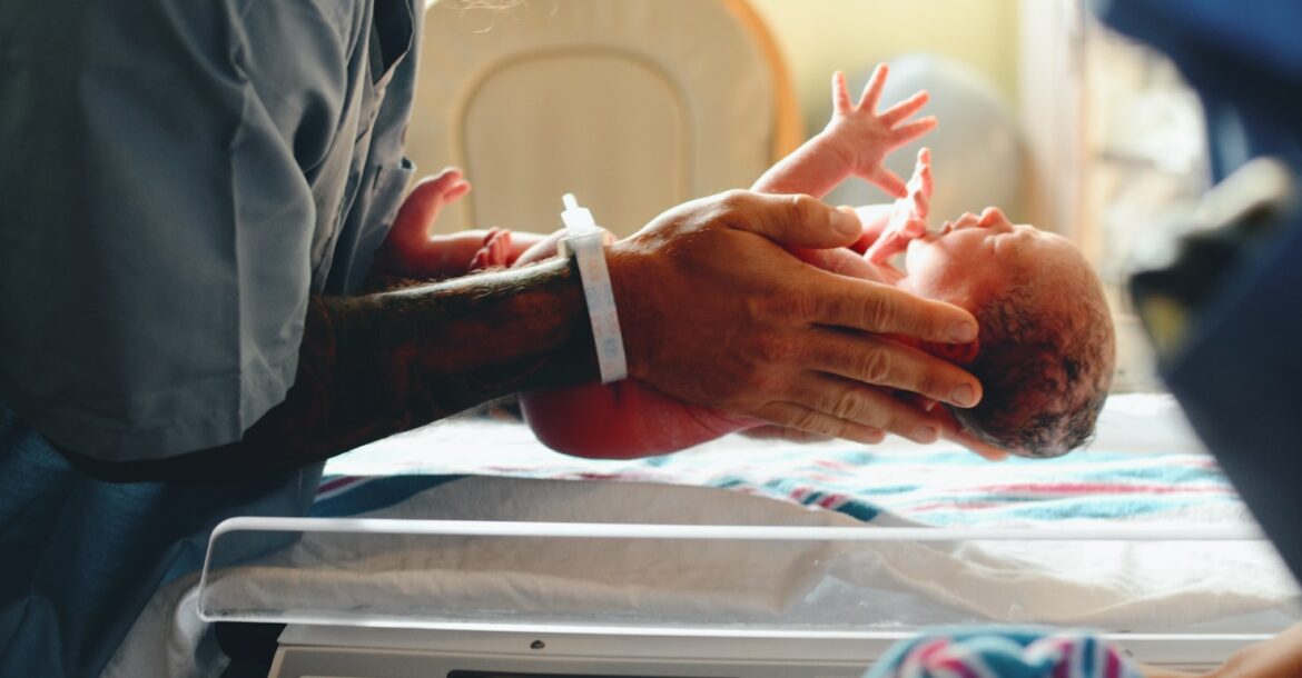 Un nouveau né dans les mains d'un médecin.