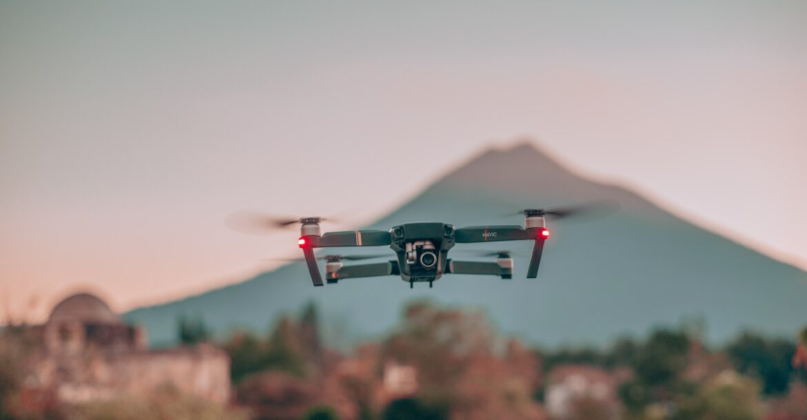 Un drone en vol stationnaire près d'une colline.